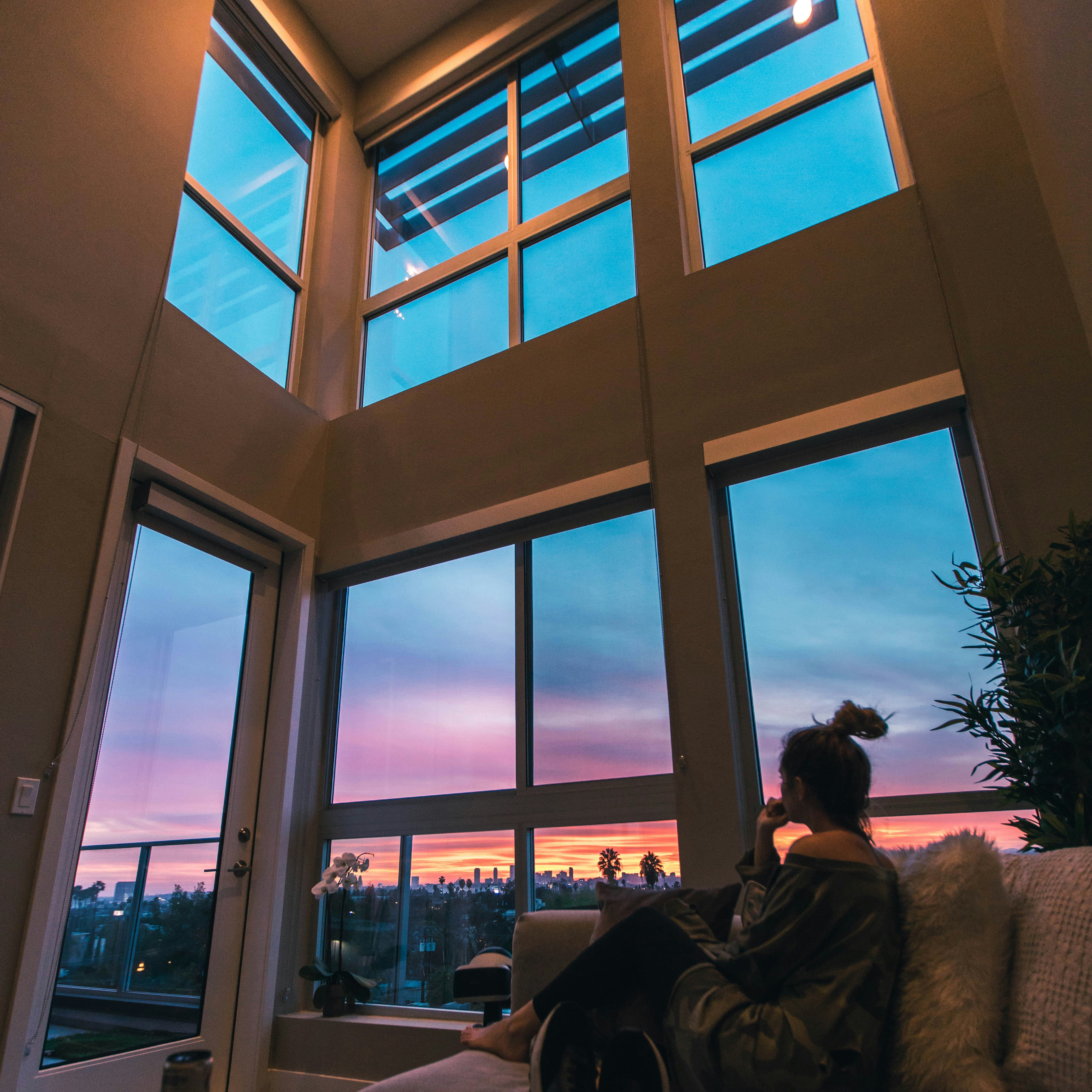 a person sitting on a couch looking out a window