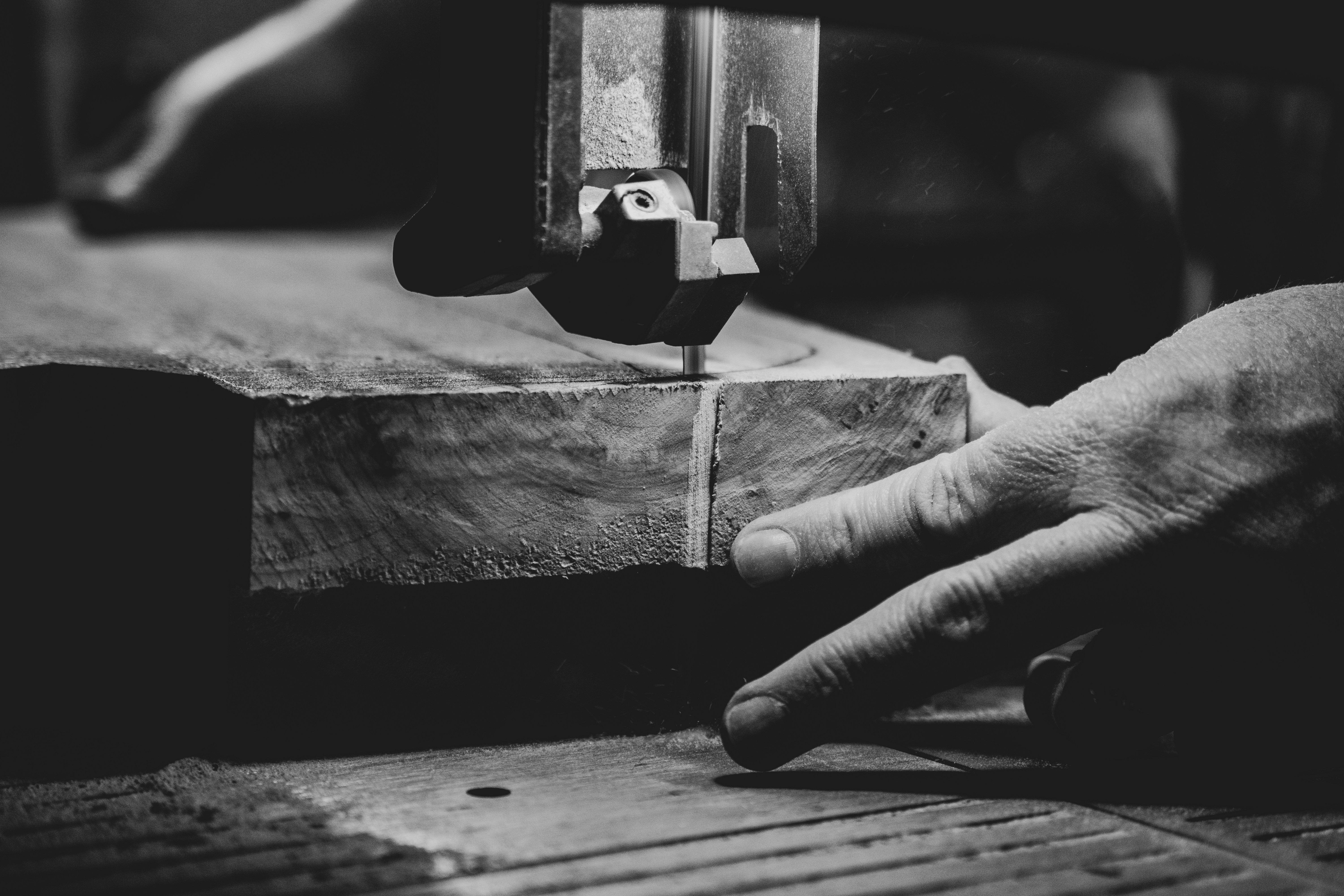 grayscale photography of person cutting slab