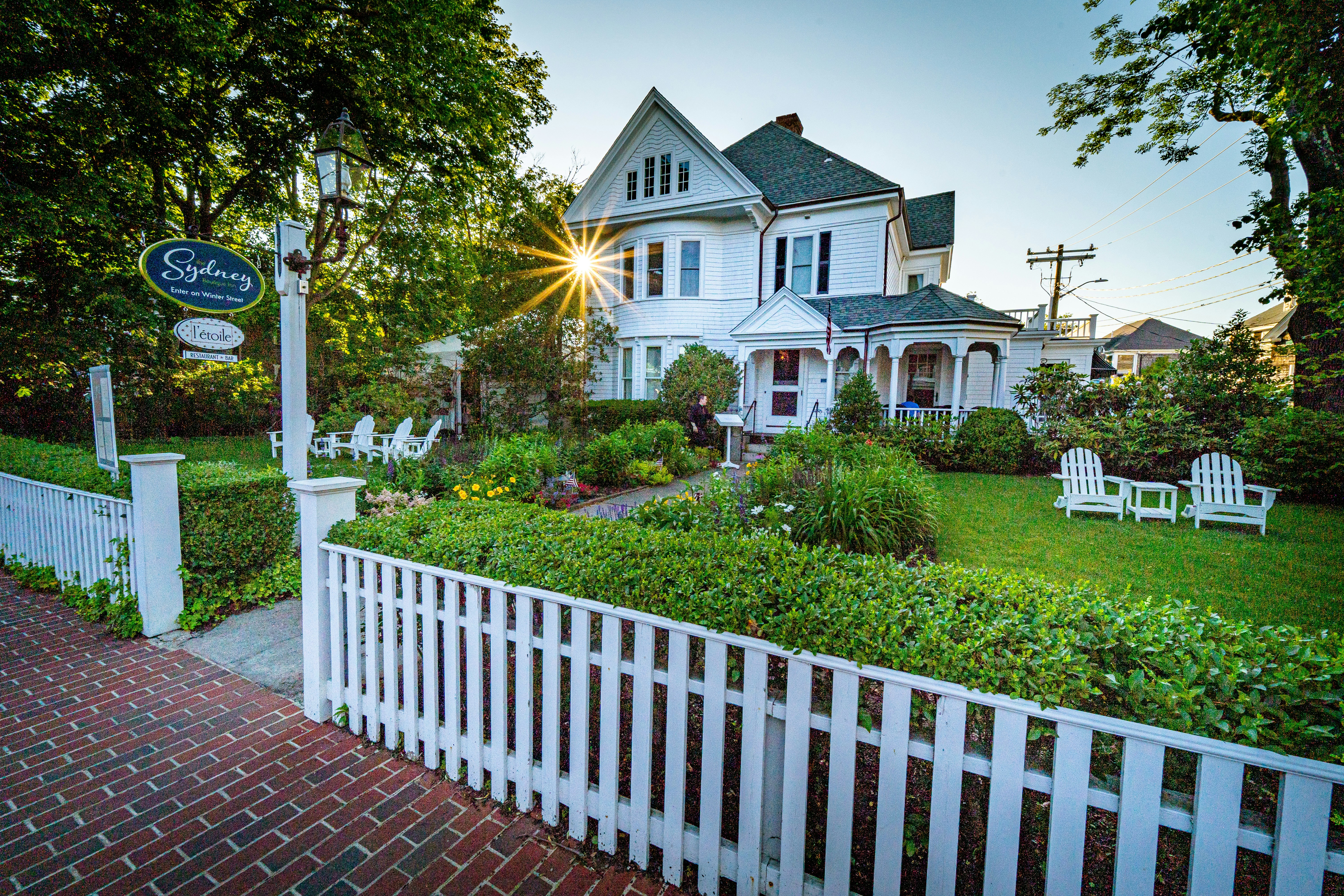 white wooden fence near white and brown house