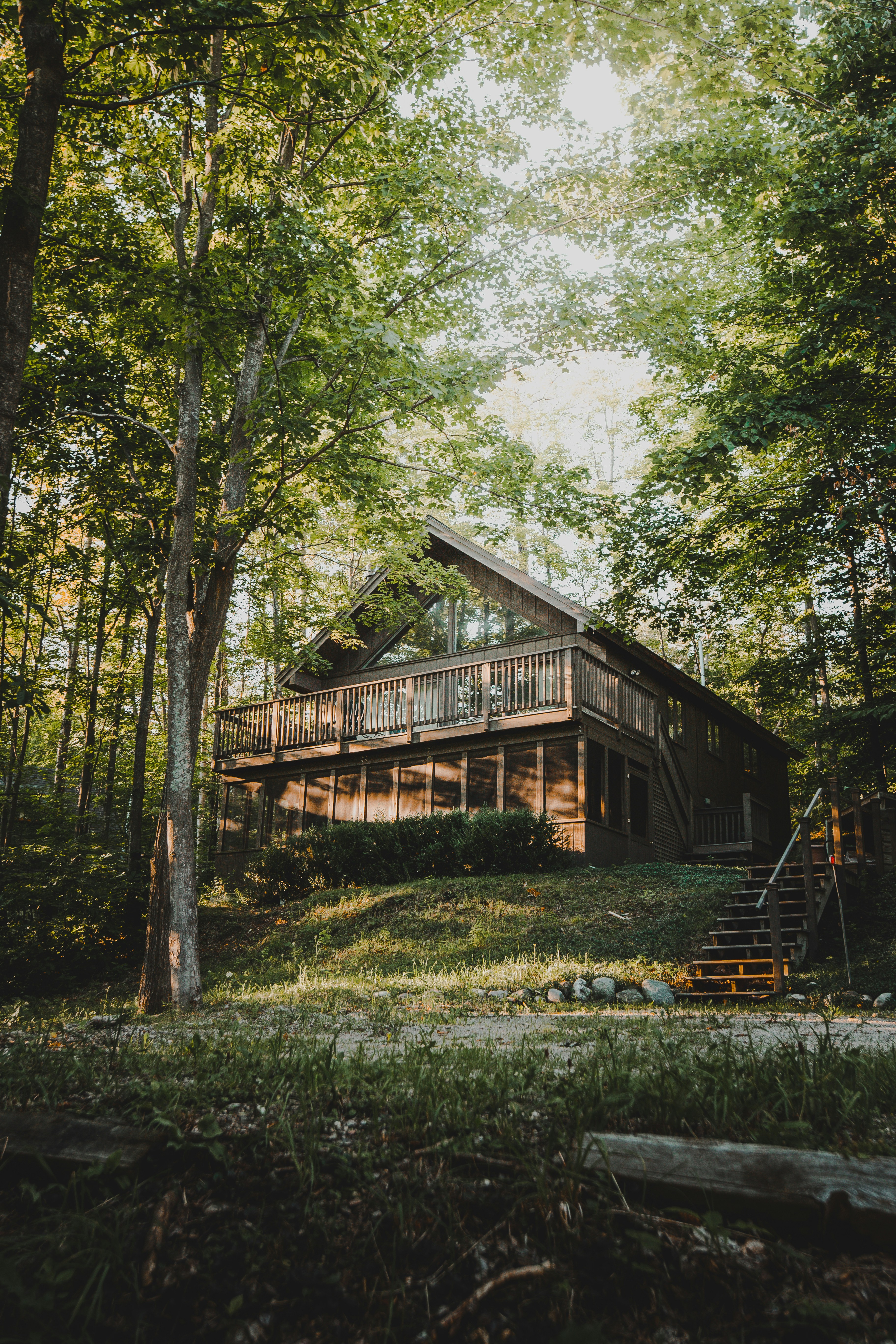 brown wooden house surrounded by green trees during daytime