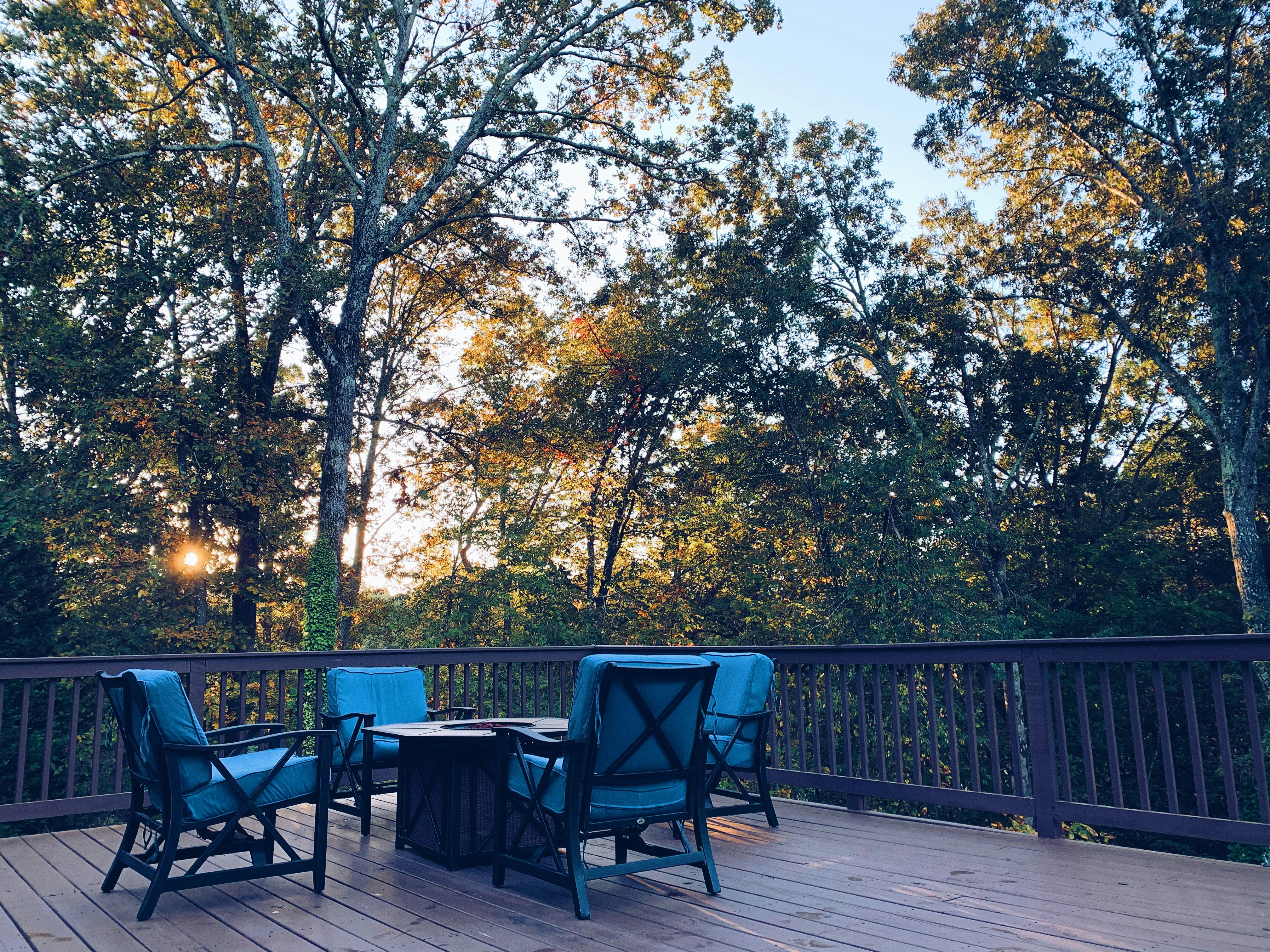 black metal chairs and table near green trees during daytime