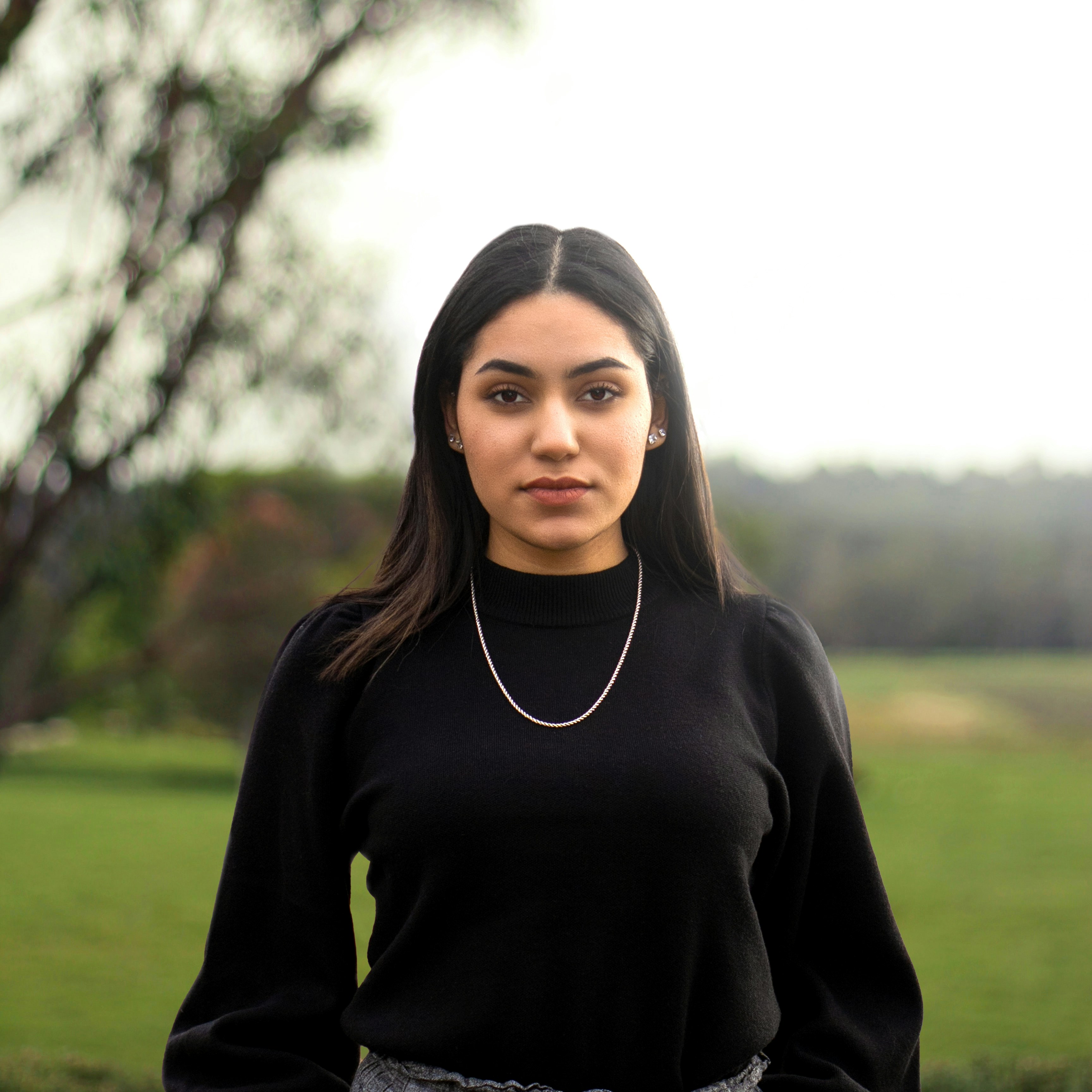 woman in black turtleneck long sleeve shirt standing on green grass field during daytime