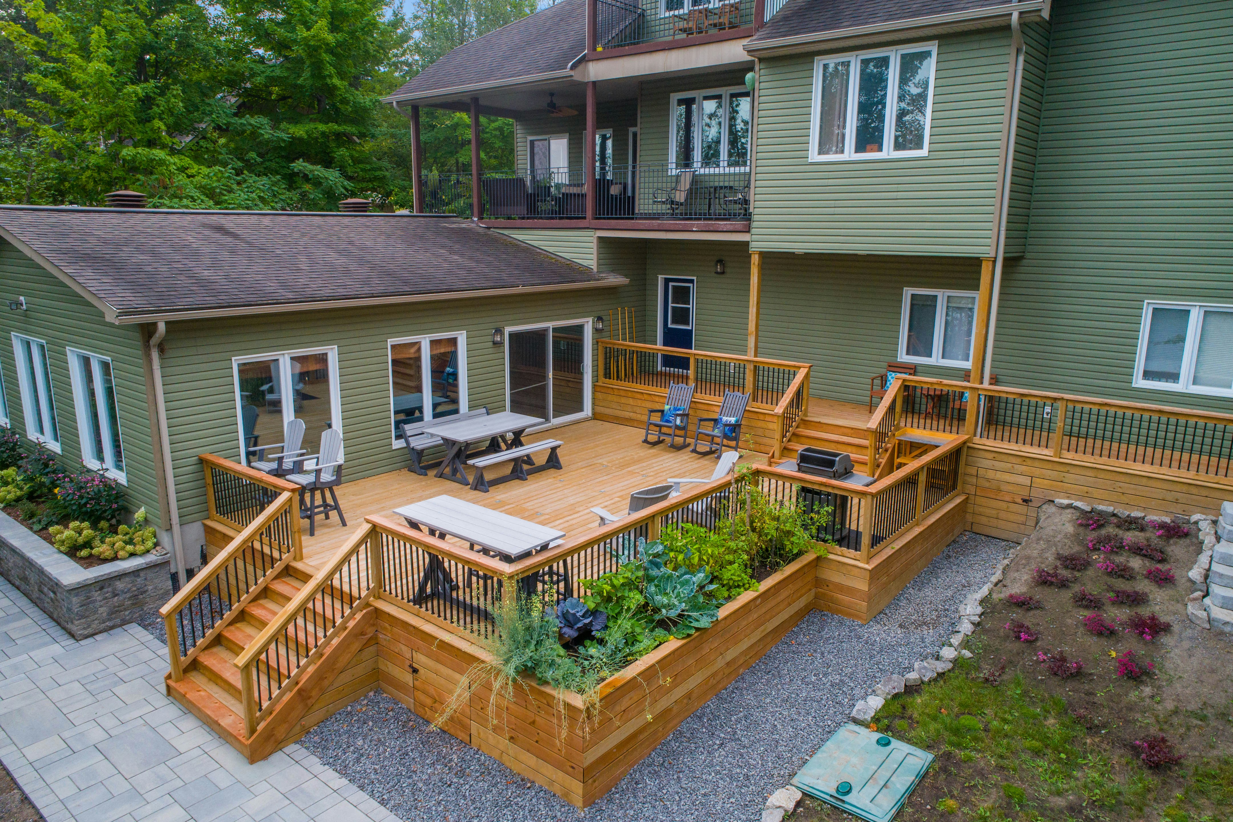 a deck with chairs and tables on it and a deck with plants