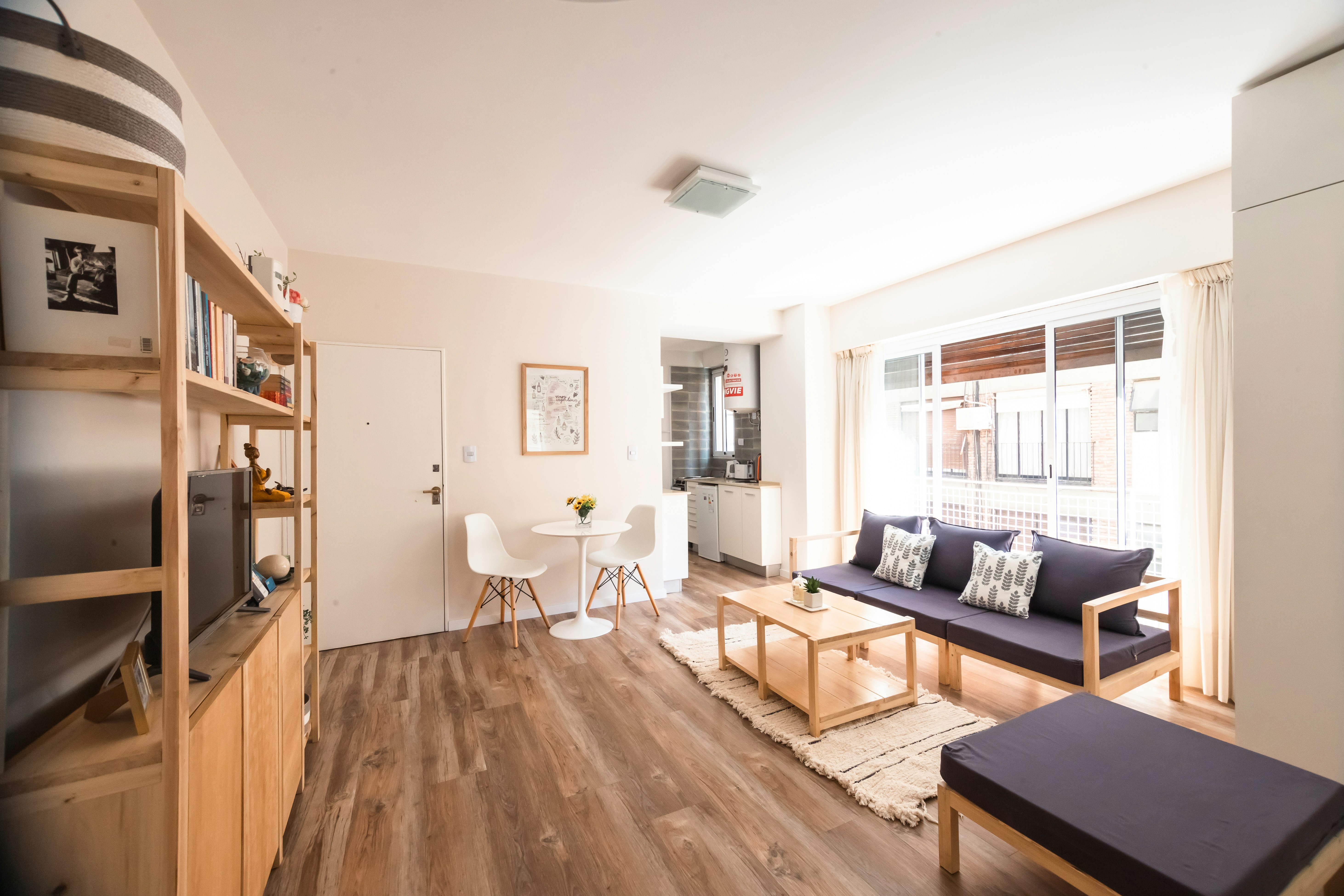 a living room with a blue couch and a wood floor