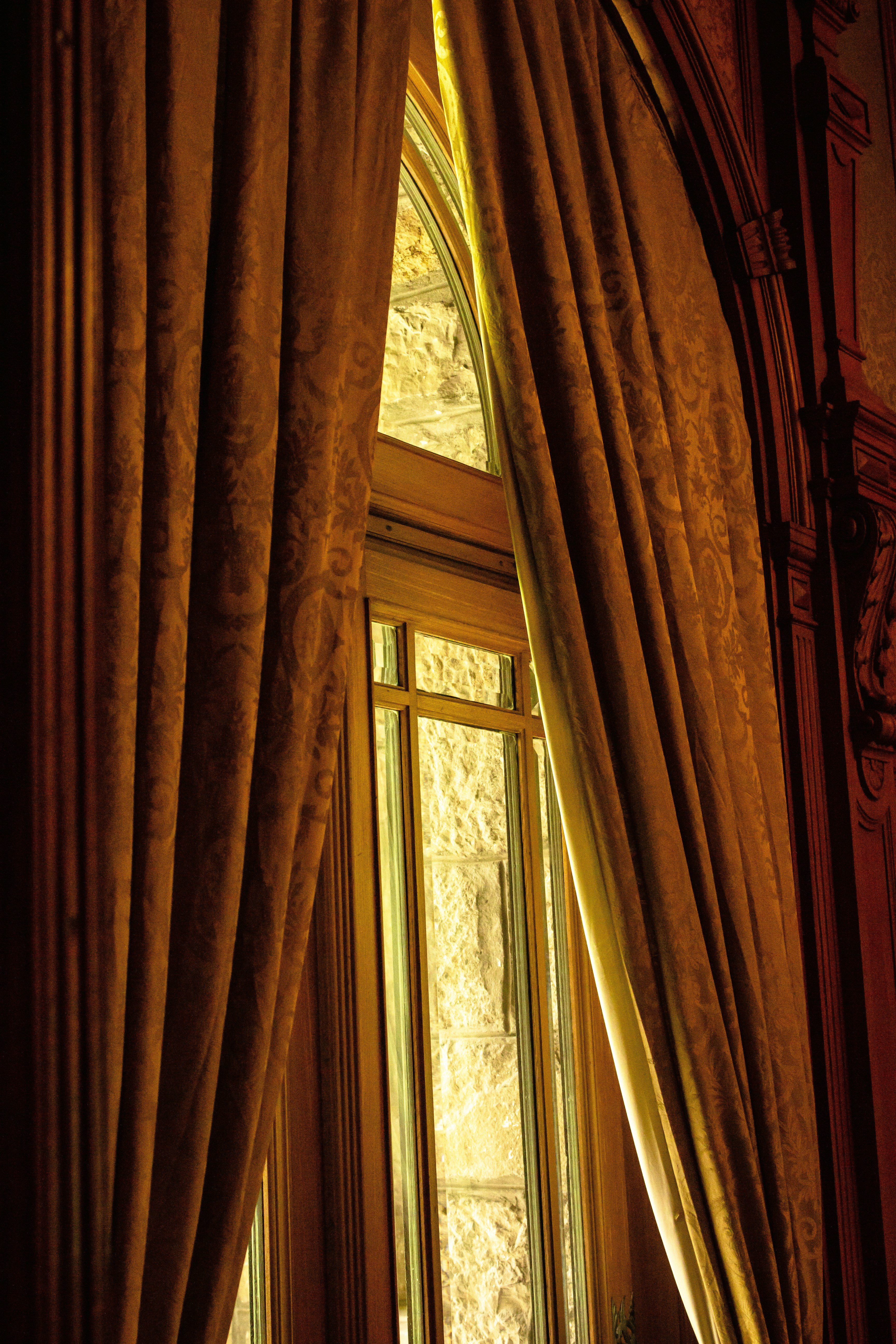 a window with curtains and a clock on the wall