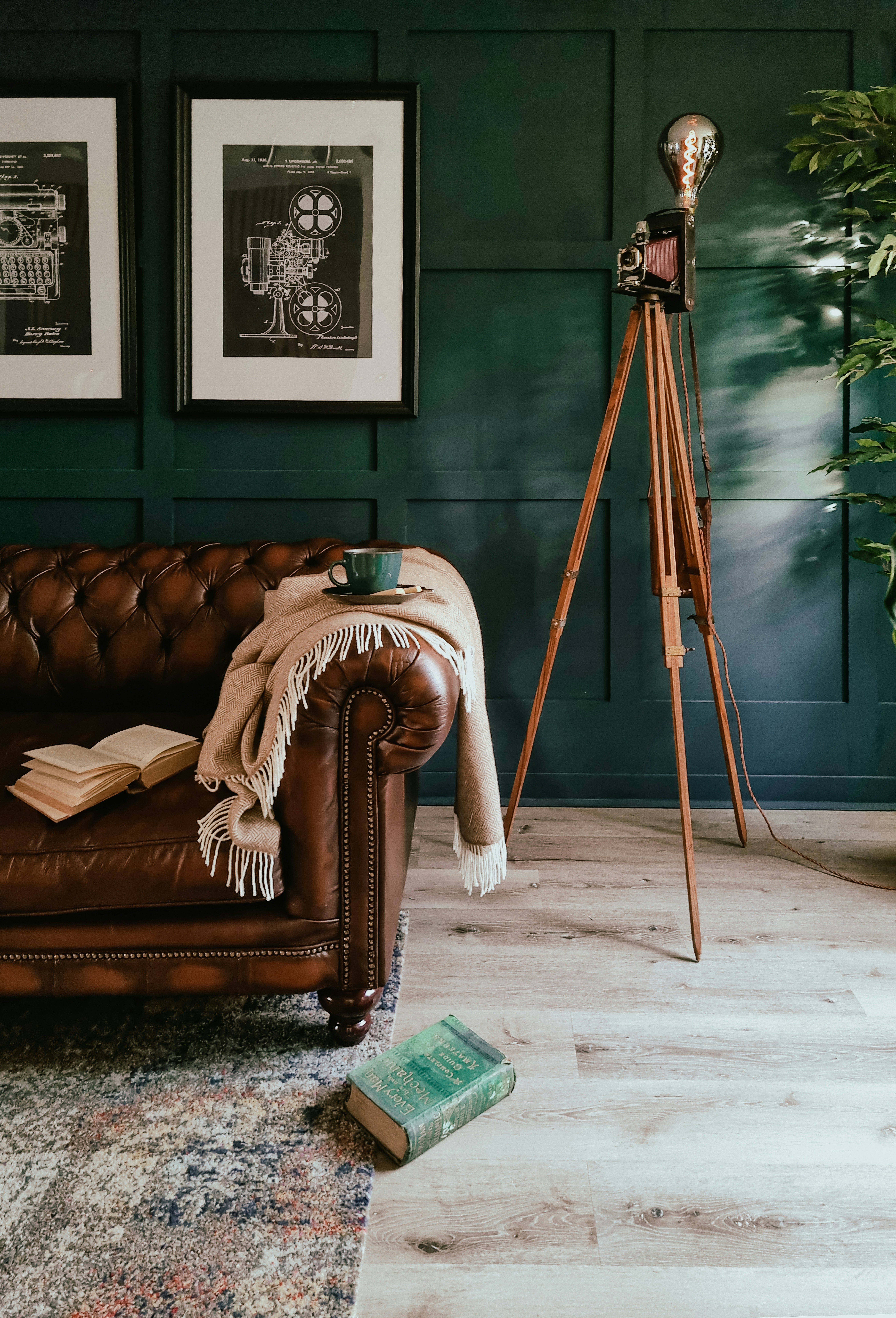 a living room with a leather couch and a tripod