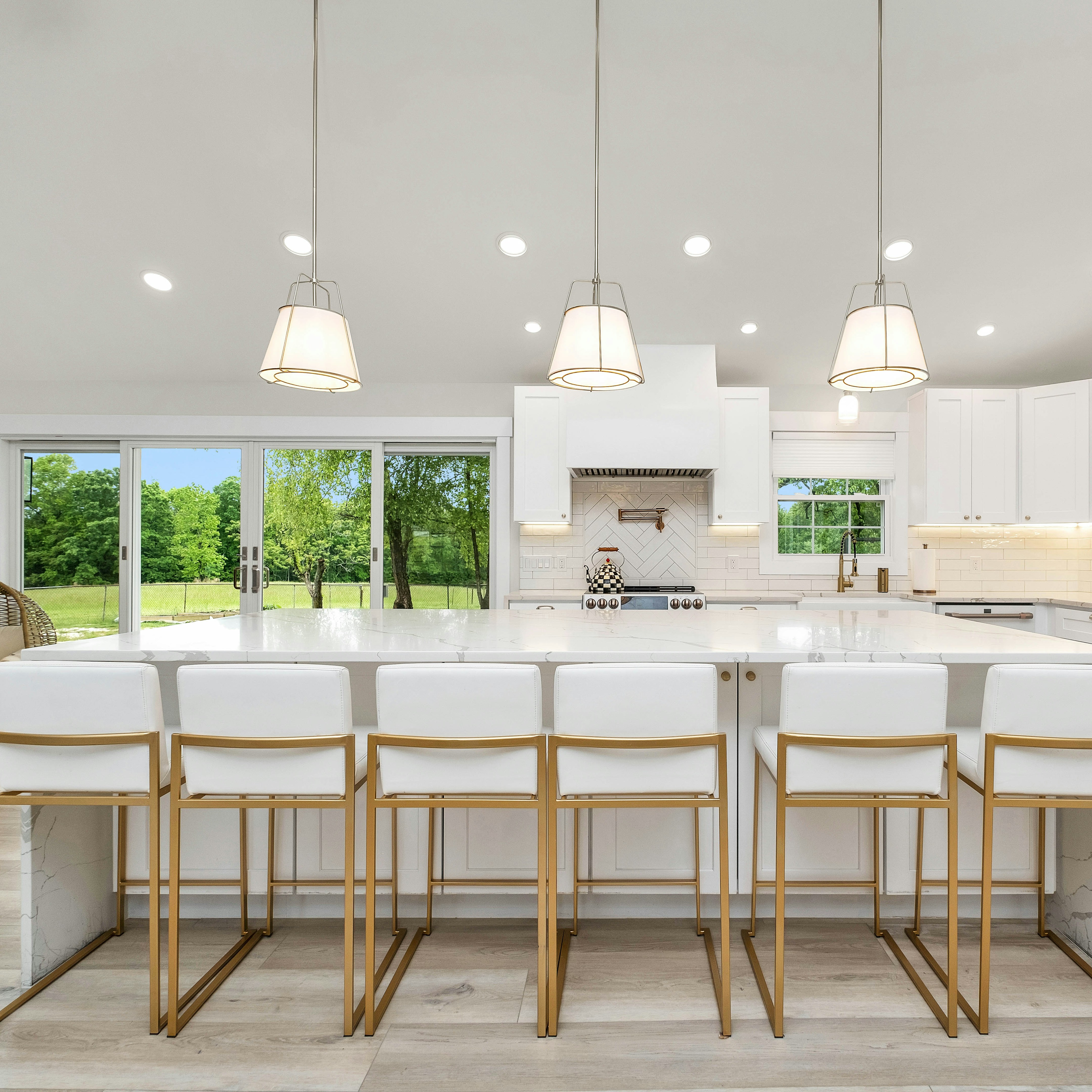 a large kitchen with a center island and white cabinets