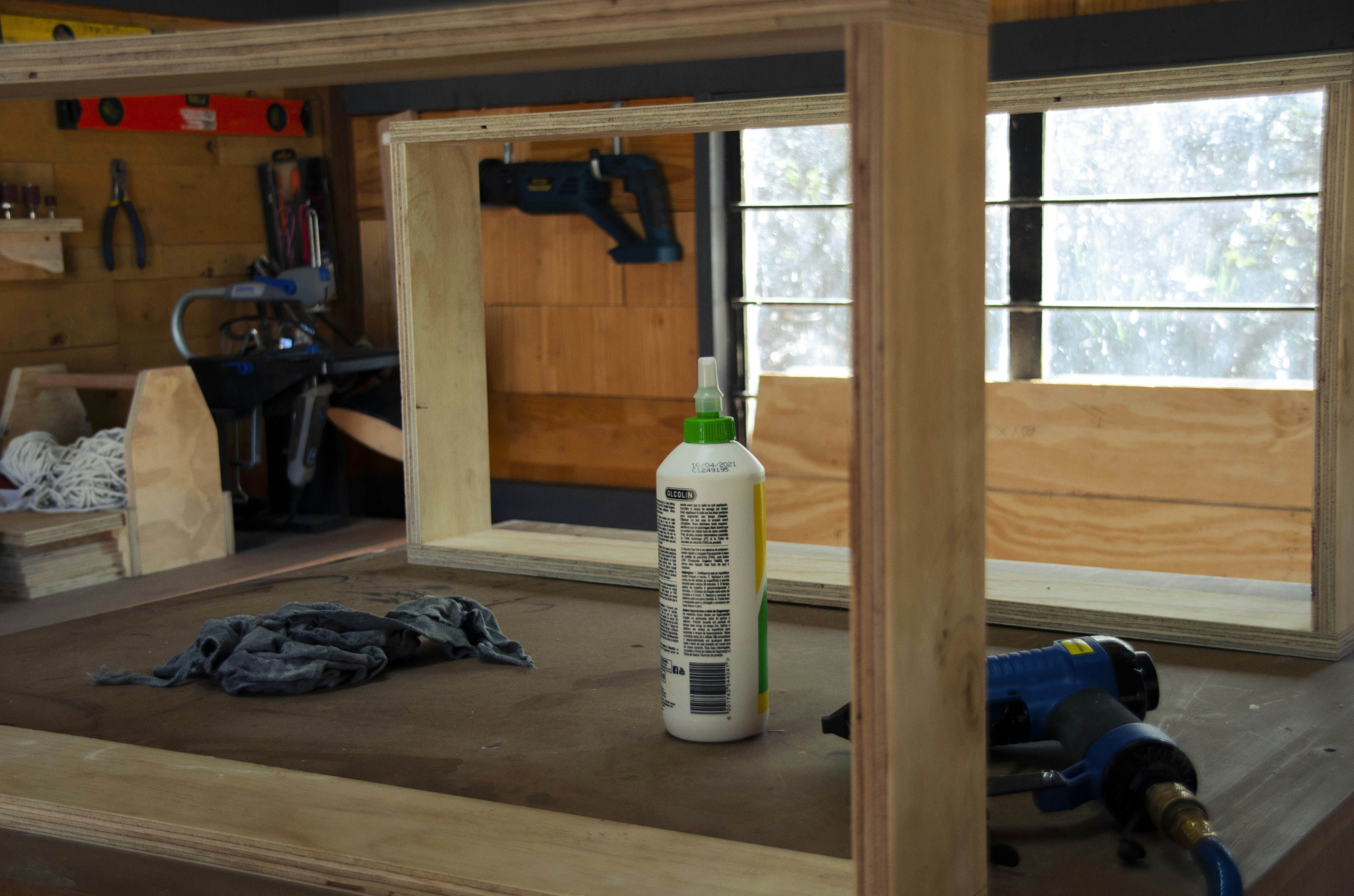 a bottle of glue sitting on top of a wooden table