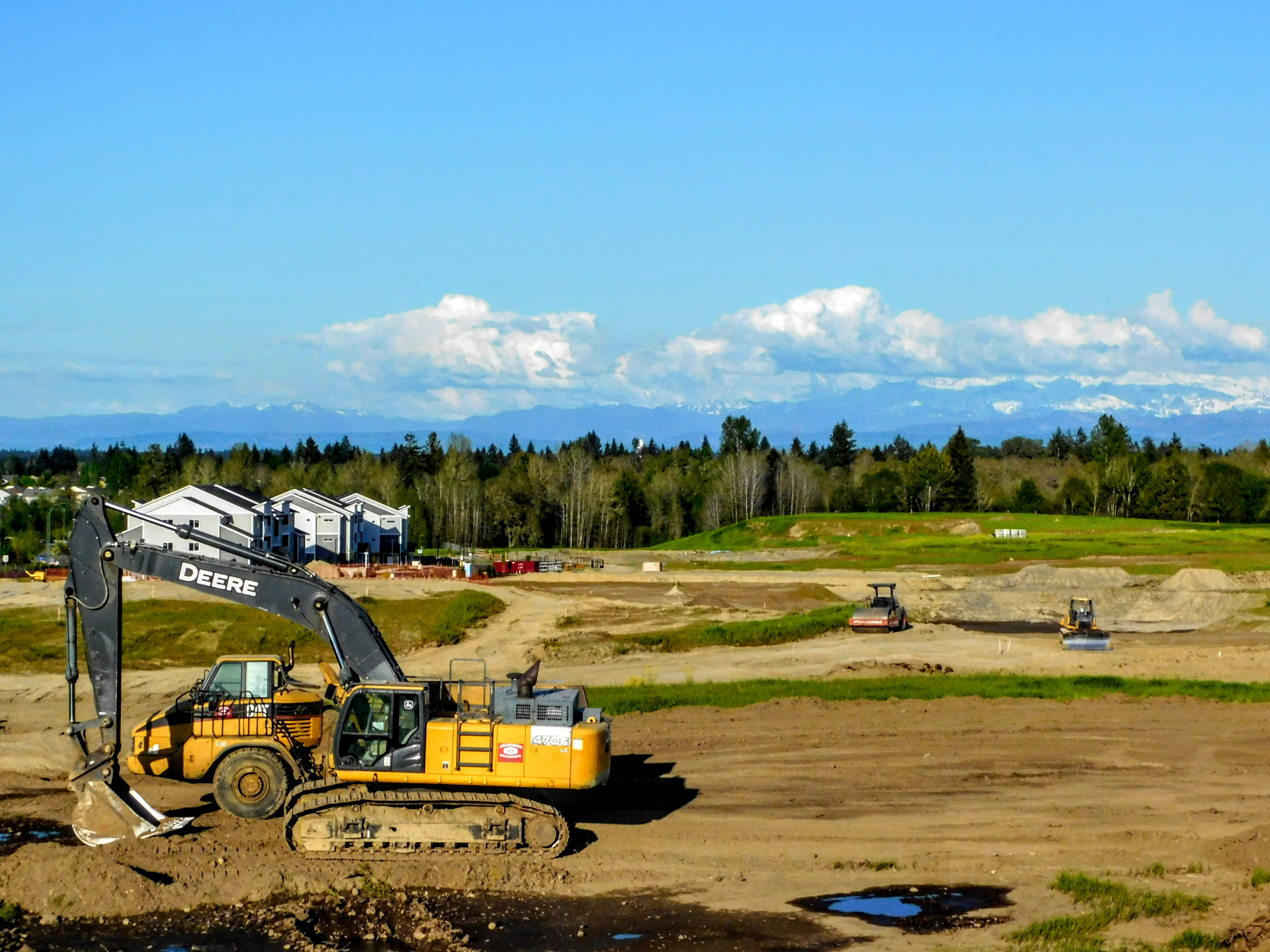 a construction site with a large excavator in the foreground