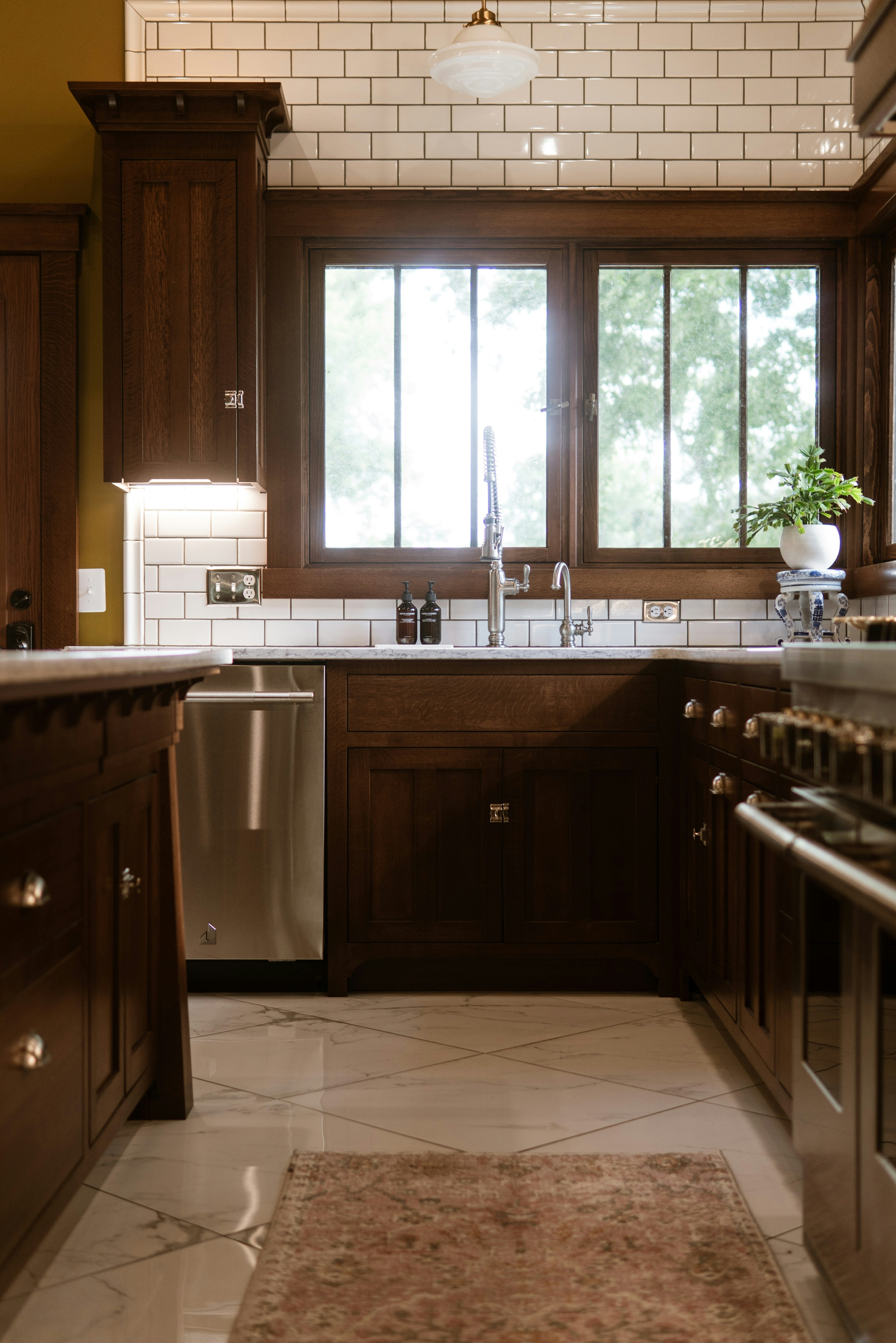 A kitchen with a sink, stove, dishwasher and refrigerator