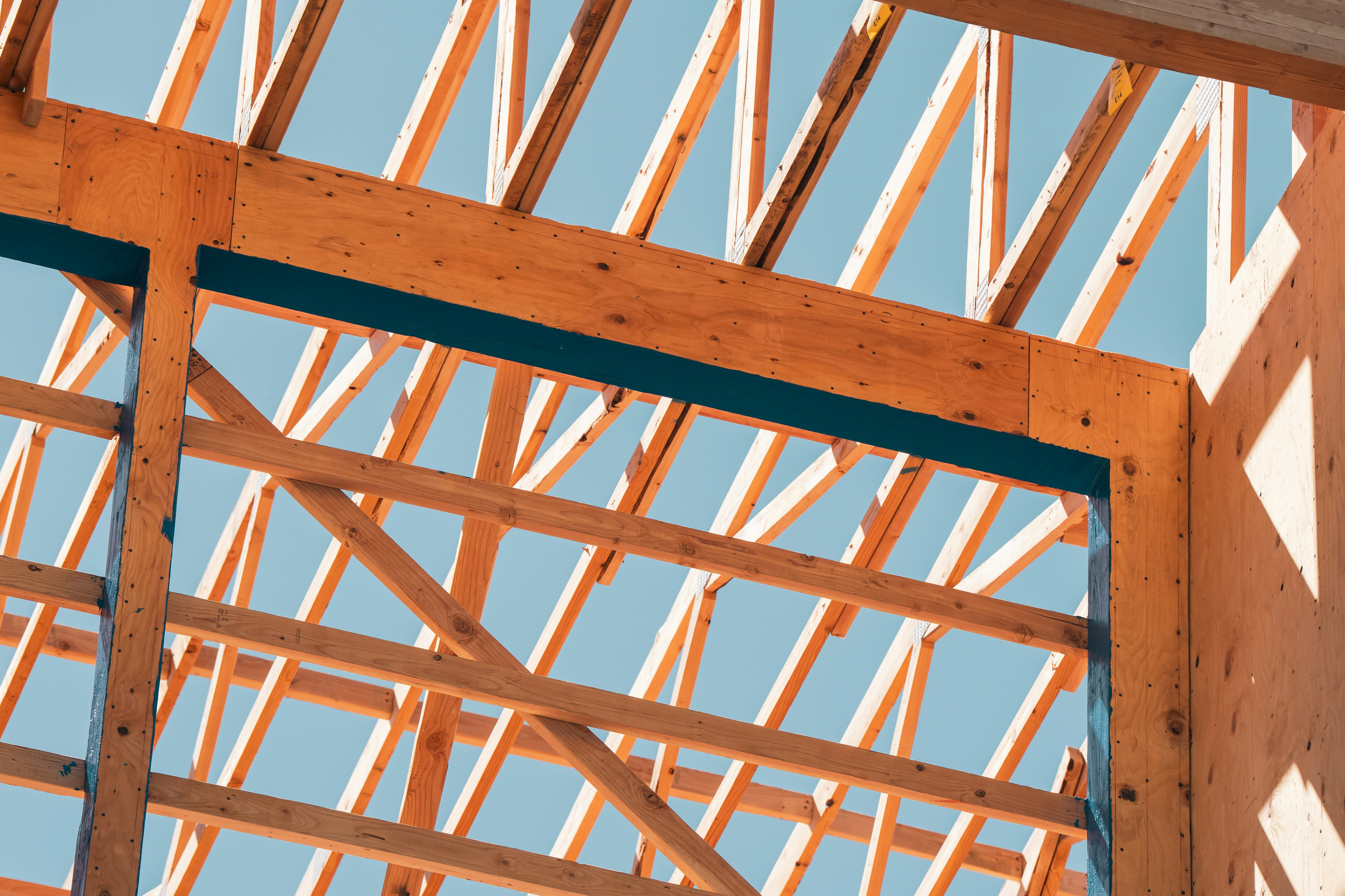 Wooden framework of a building against a blue sky.
