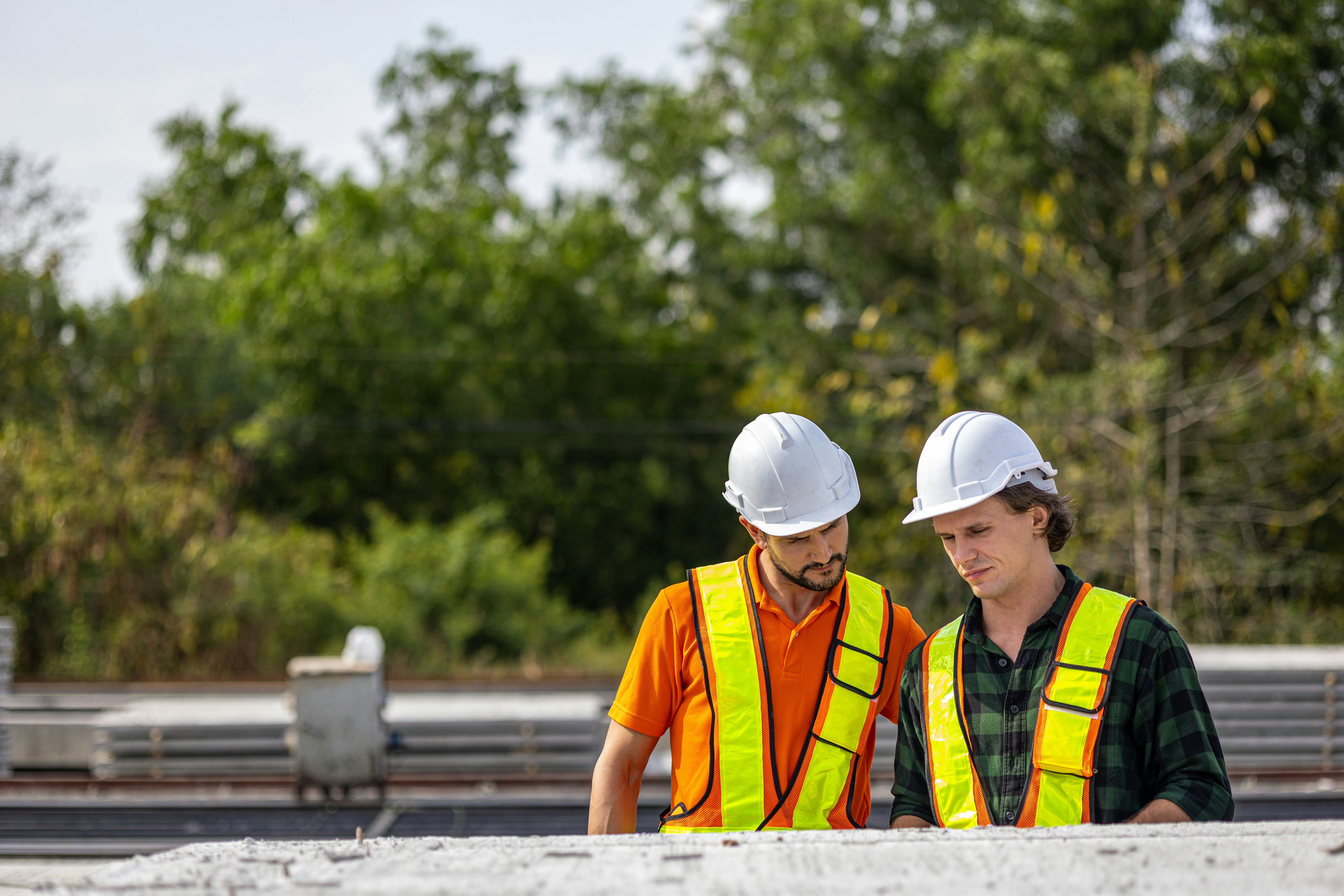 Construction workers examine plans on site.