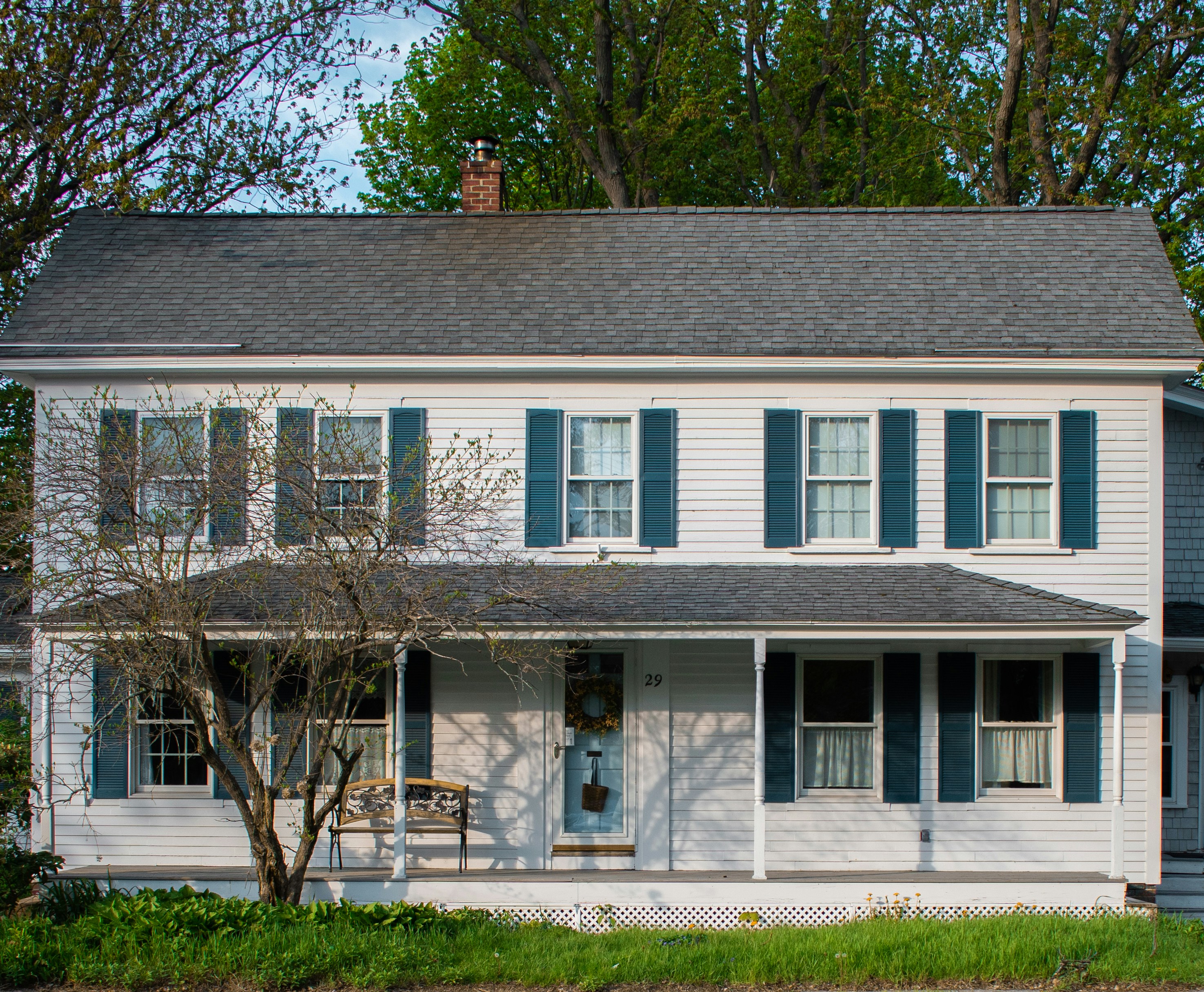 A white house with blue shutters and a porch.