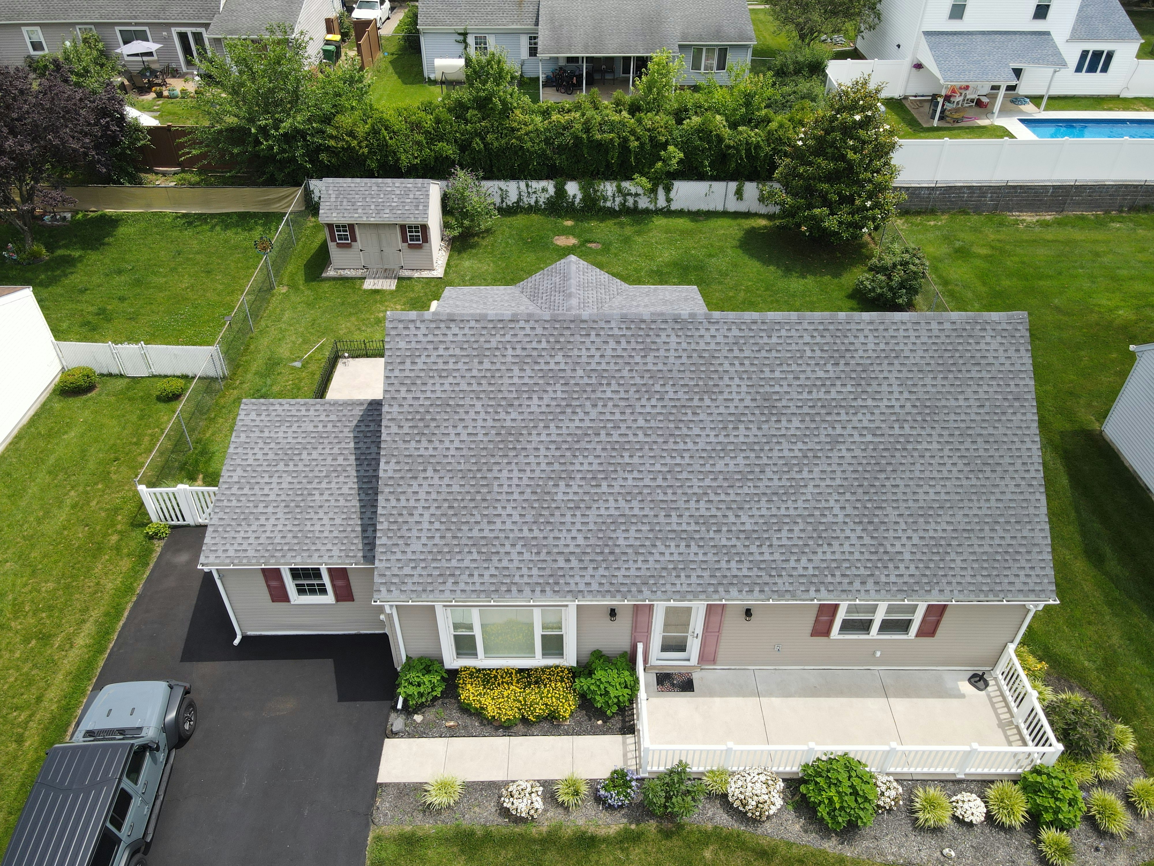Aerial view of a house with a grey roof being repaired in VT