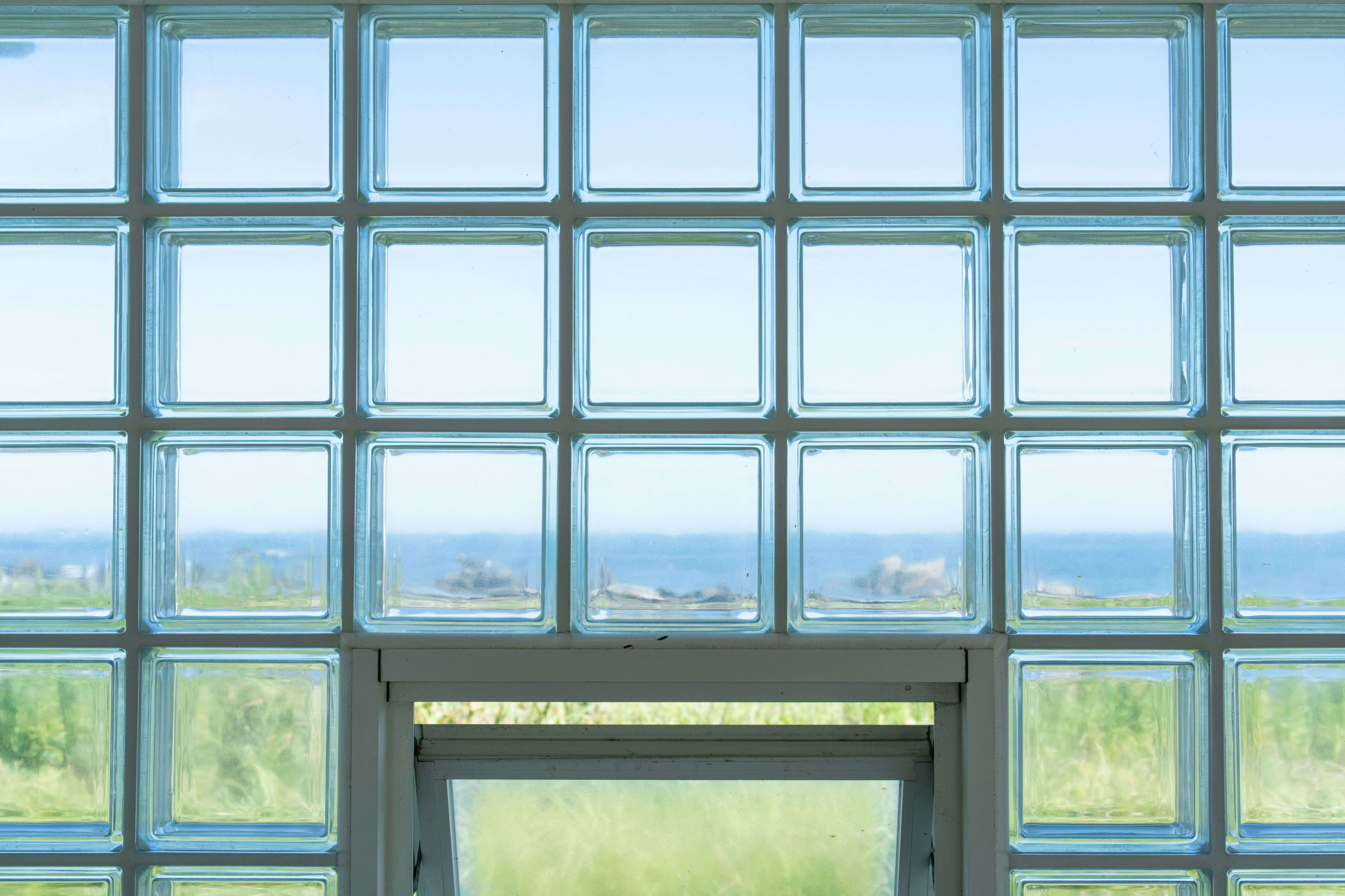 Glass block window overlooking ocean and green grass