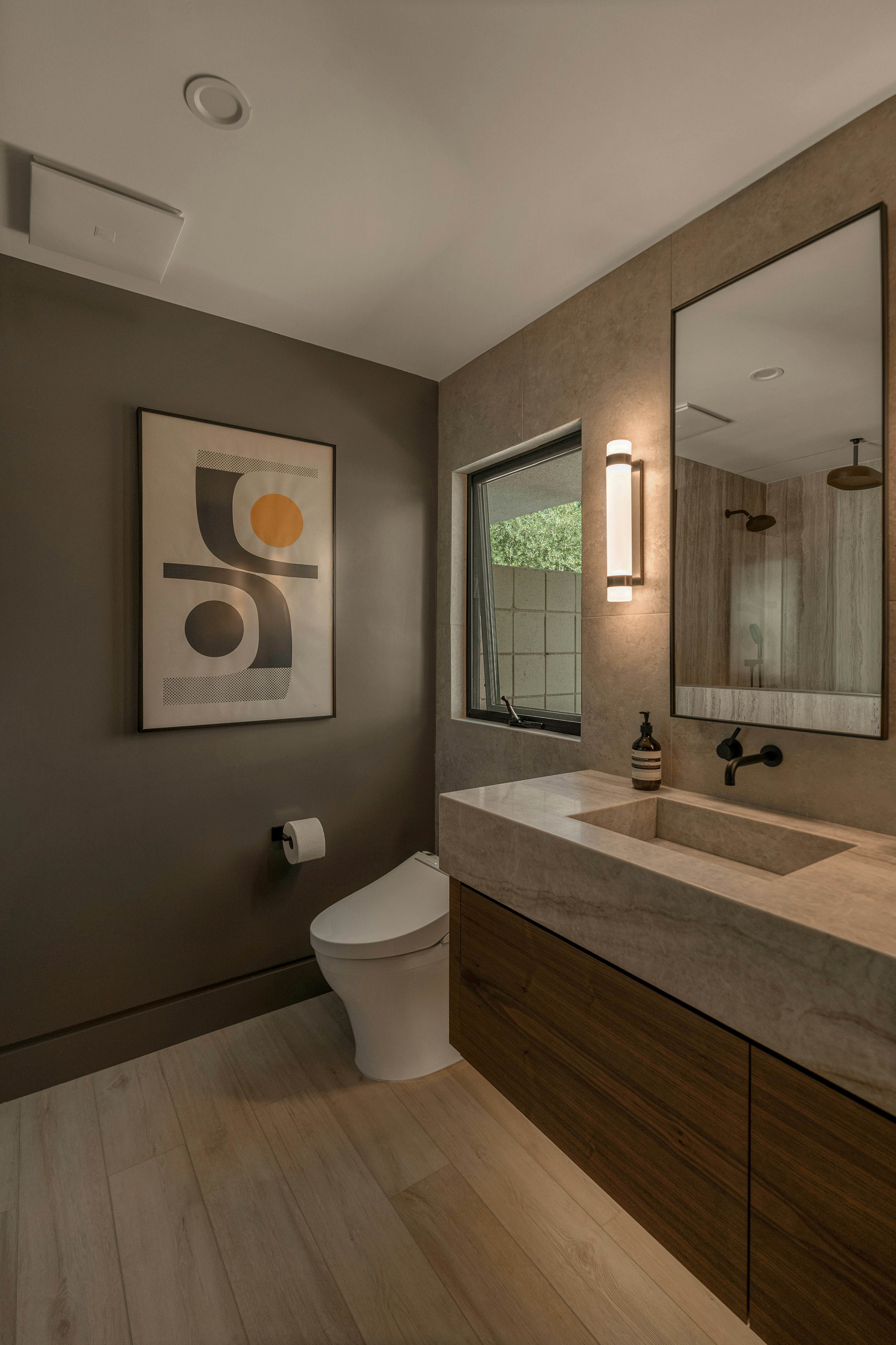 Modern bathroom with a floating vanity and abstract art.