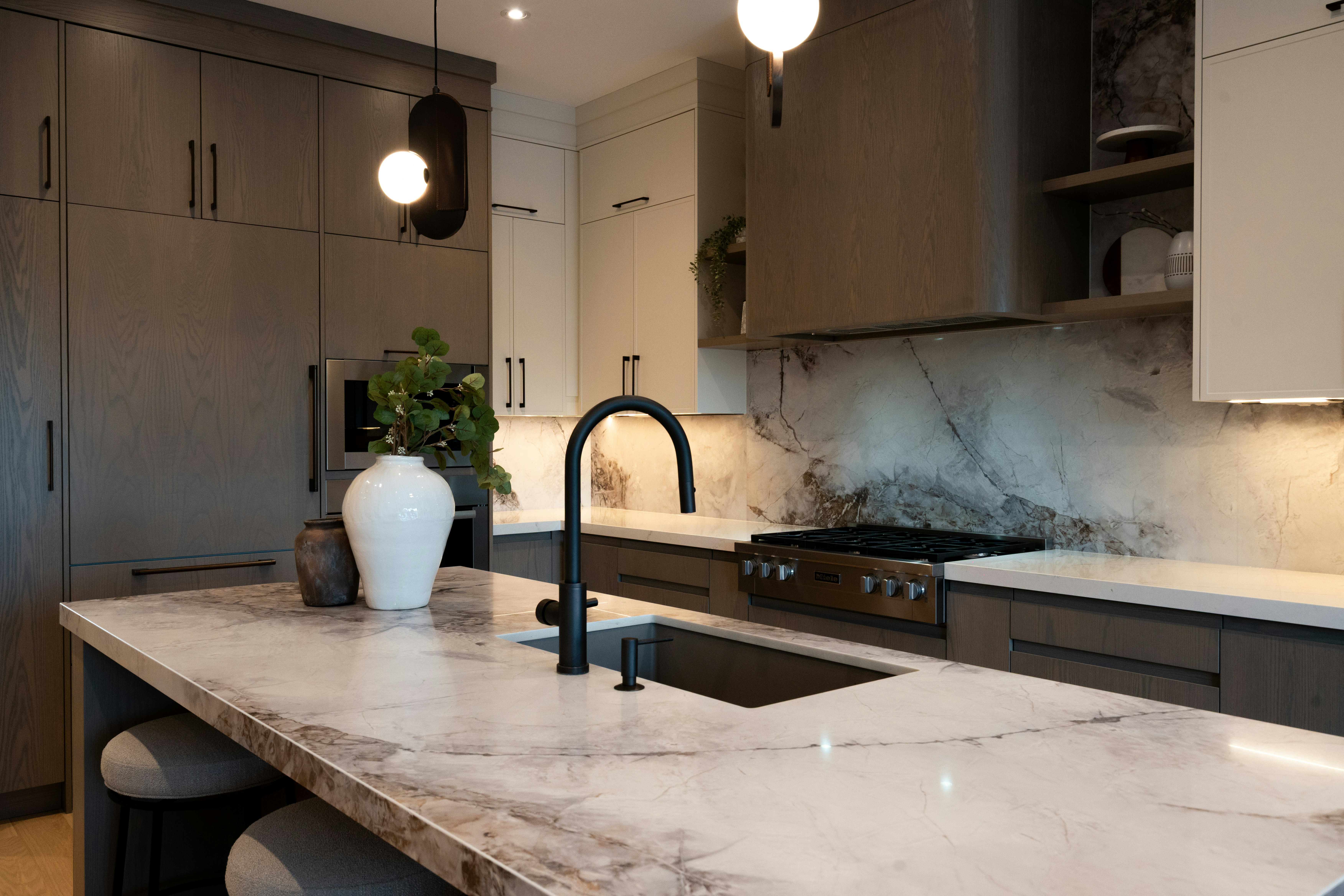 Modern kitchen with marble island and dark faucet