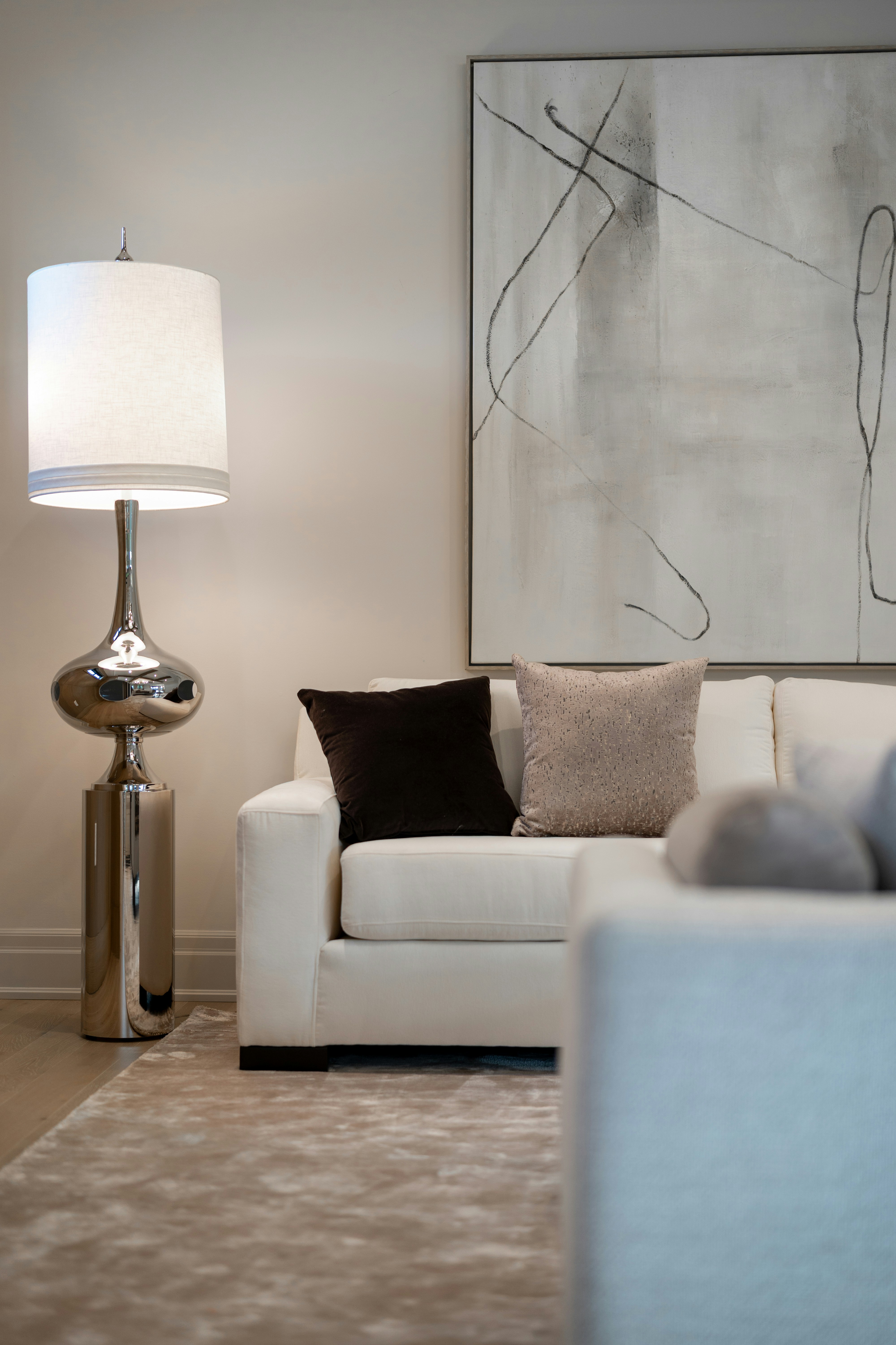 Modern living room with white sofa and abstract art.